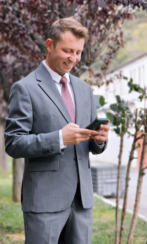 a man in a suit holds a cell phone