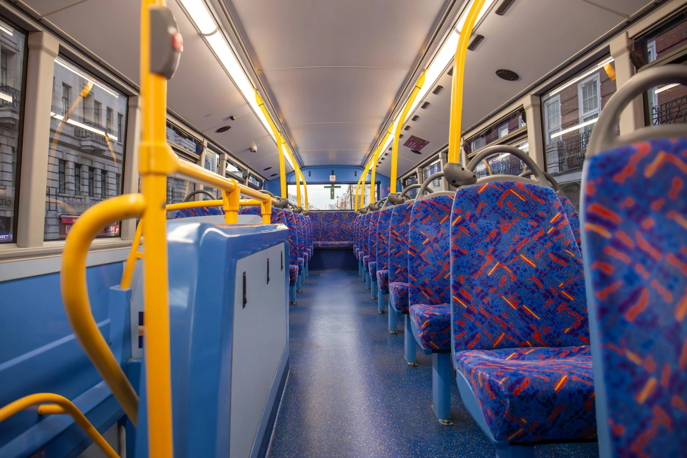 the interior of a bus with yellow and blue seats