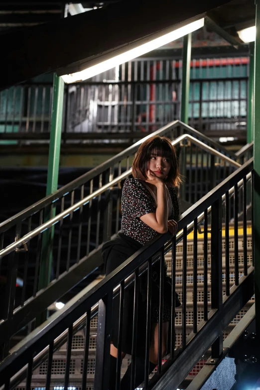 the young woman is standing on the rails