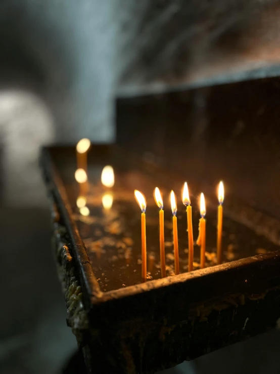 a group of lit candles on top of a wooden table