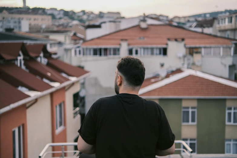 a man standing on top of a building with the sun low in the sky