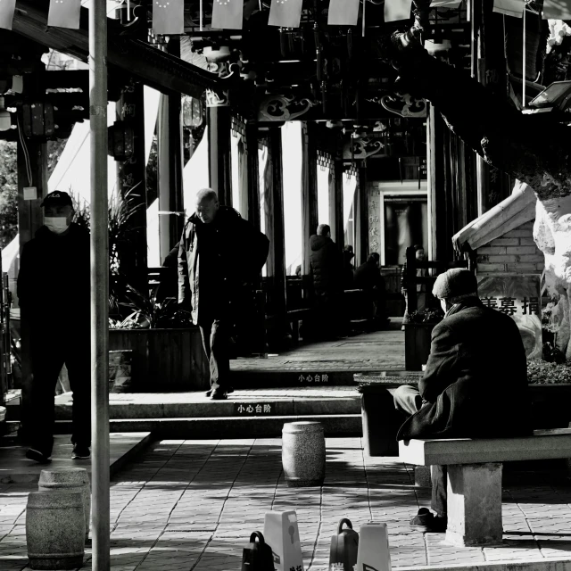 a man sits on a bench in a park next to a couple