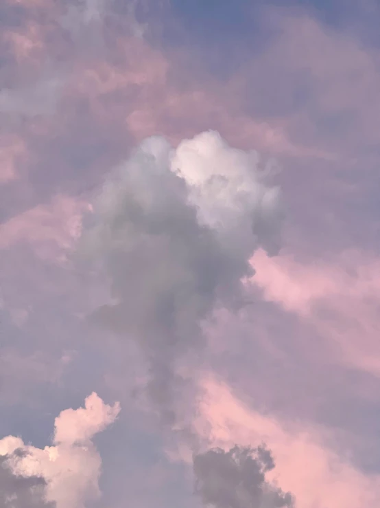 a plane flying through the sky on a cloudy day