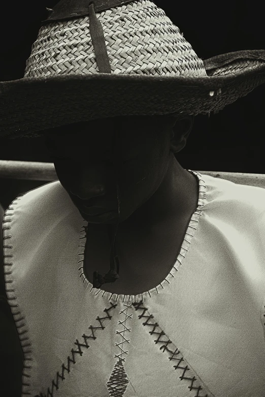 an old woman wears a straw hat with no lining on it