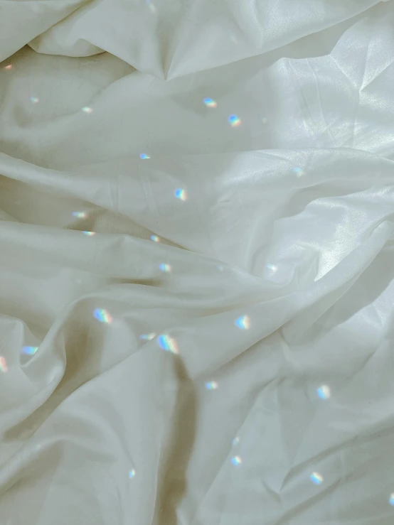 a close up of white cloth with white glitters