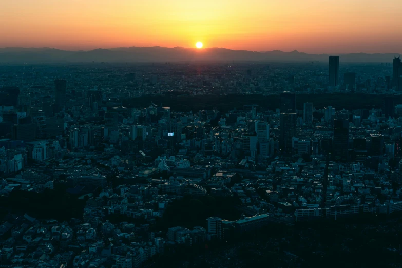 the sun setting over some very tall city buildings