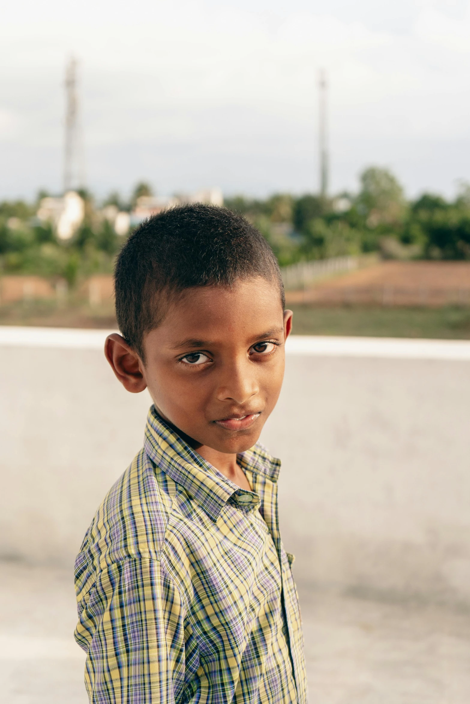 a little boy standing near a wall with soing on his face