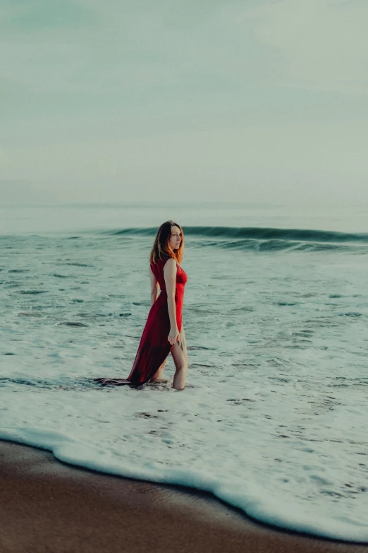 the girl walks out into the water as she is headed into the ocean