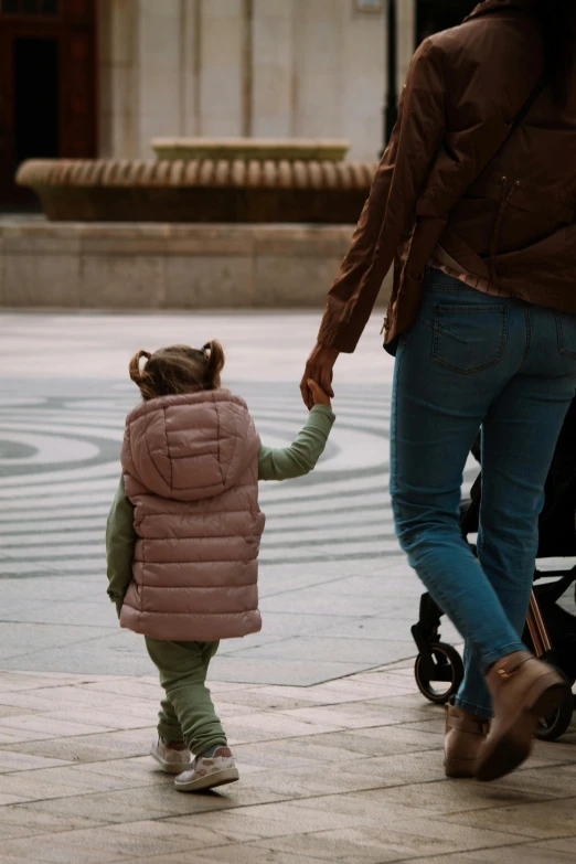 an adult and small child walking with one holding the hand