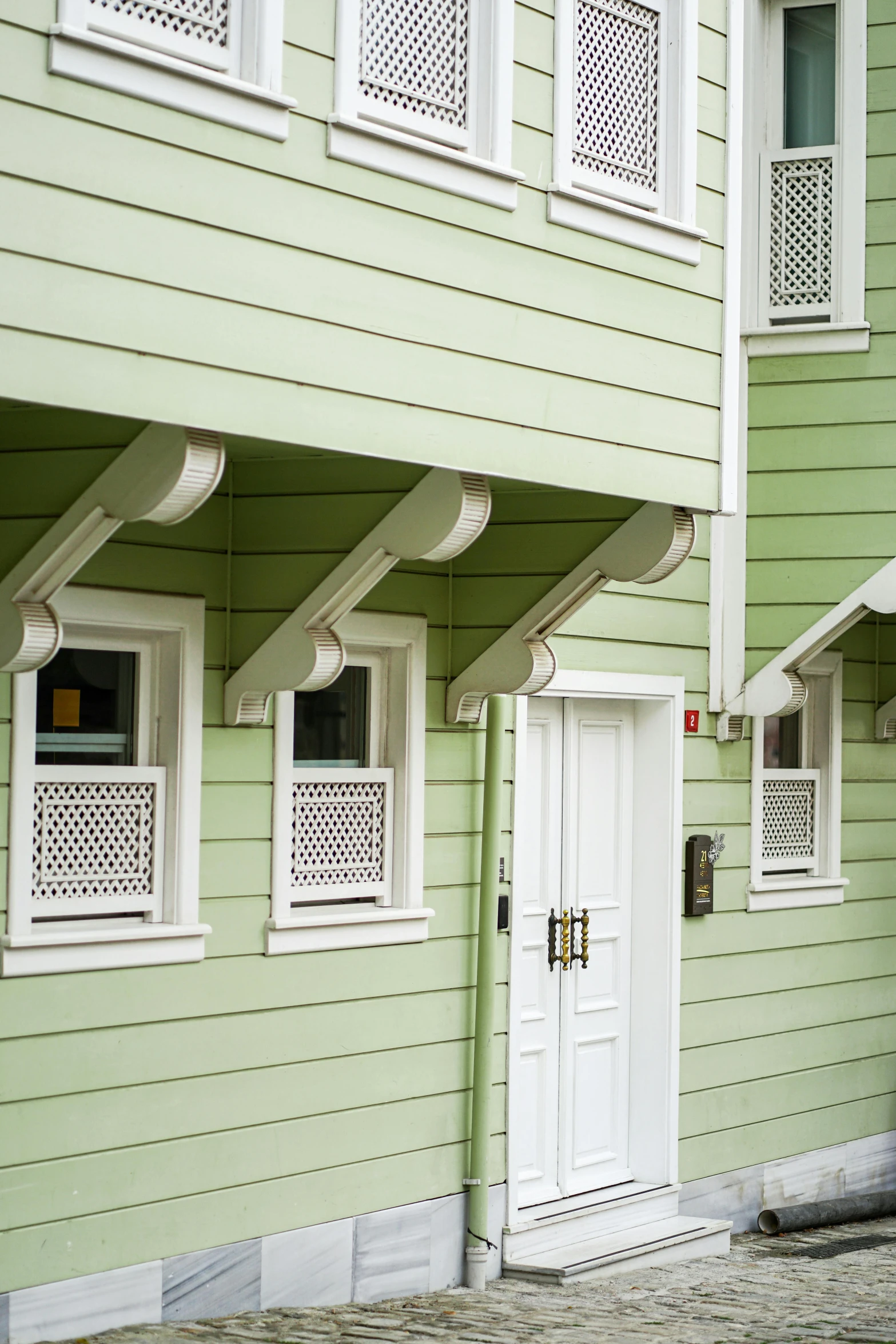 a building with three windows and some white shutters