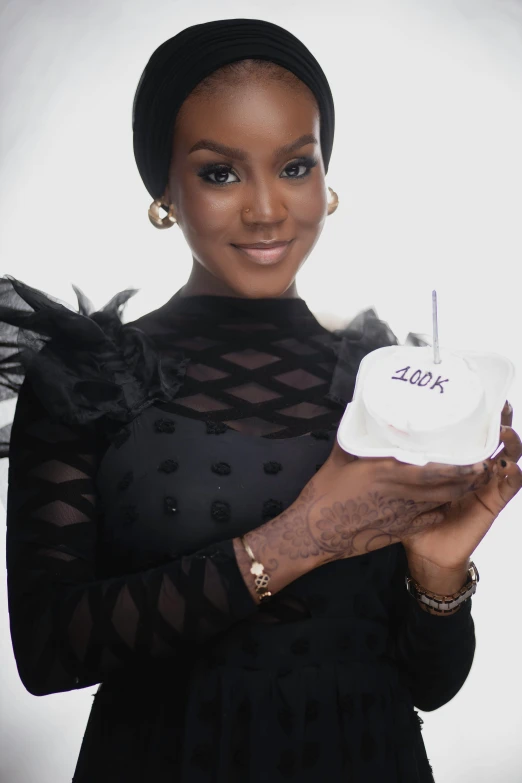 a woman holding a birthday cake in her hands