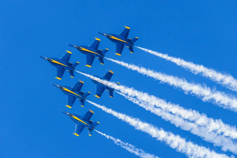 six blue angels aircraft flying in formation in the blue sky