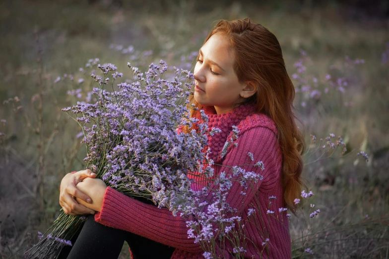 a girl in the middle of purple flowers with her eyes closed