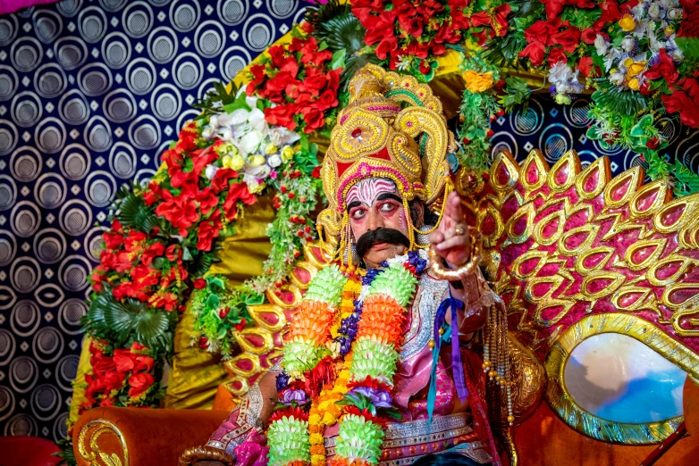 a man sitting on a couch with many decorations around him