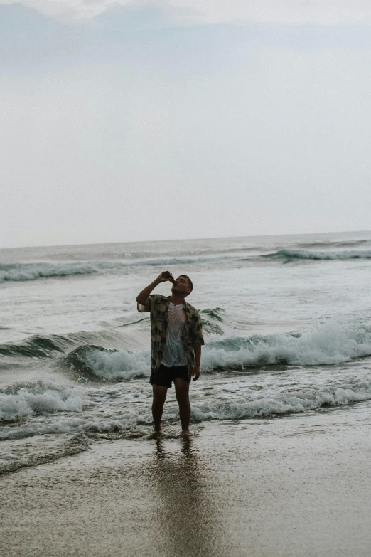 man standing in the ocean on a cloudy day