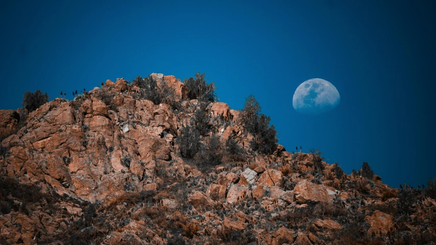 full moon in the sky with rocks and trees