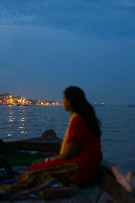 woman sitting on a boat on the ocean in the background