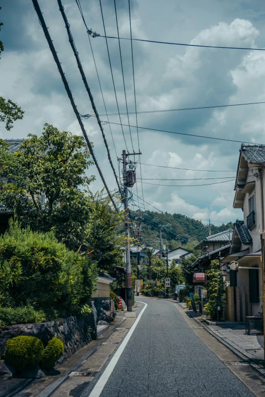 empty street between two buildings on both sides with wires above them