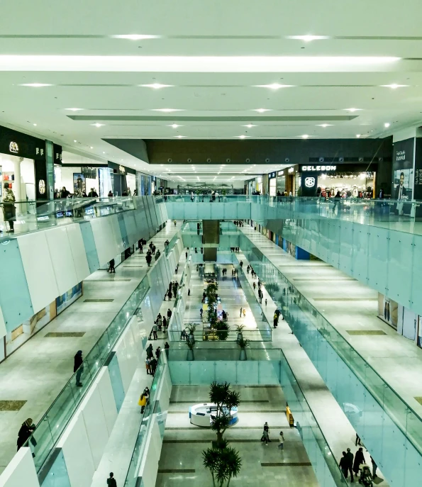 a group of people walking down a walkway next to escalators