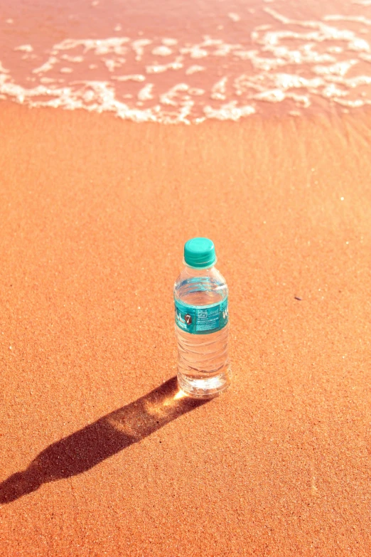 a bottled bottle of water is on the beach