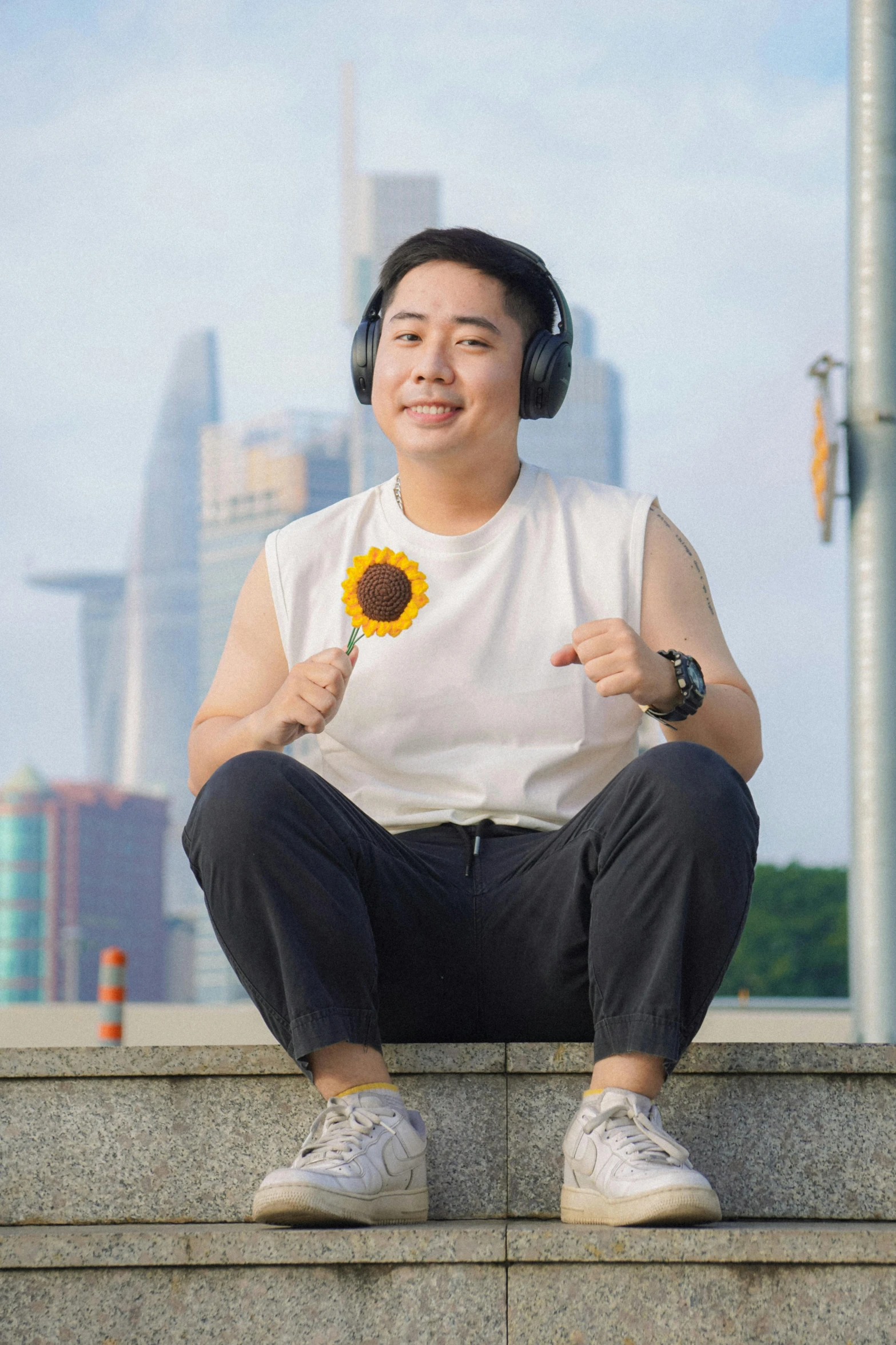 man with sunflower wearing headphones on a sunny day