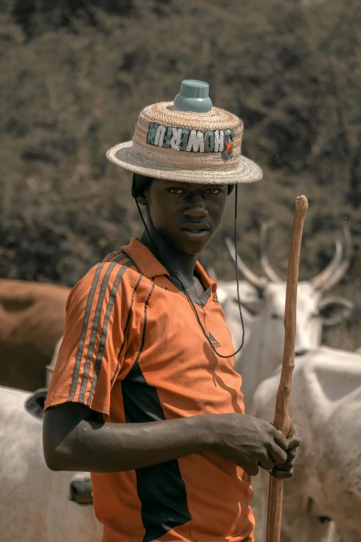 a man holding a stick and wearing a hat