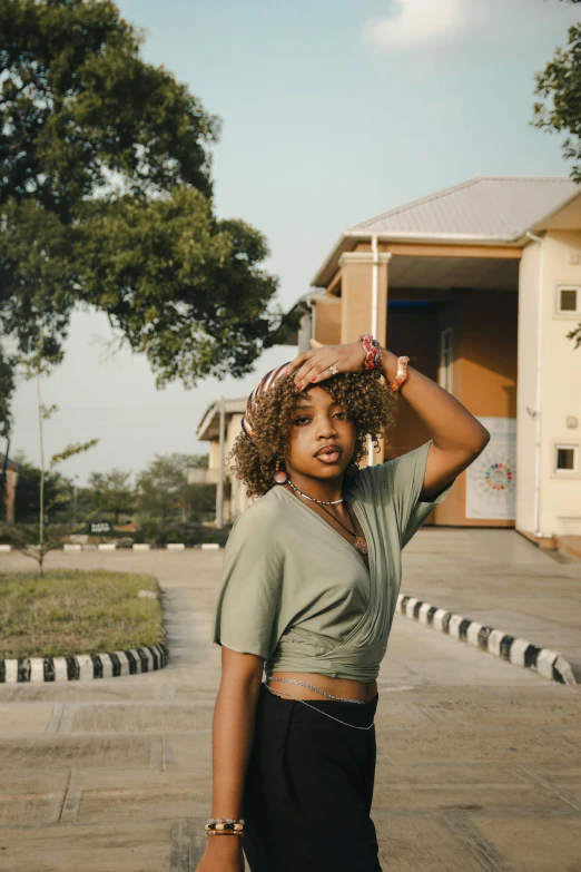 a woman holding her hair near her head in the street