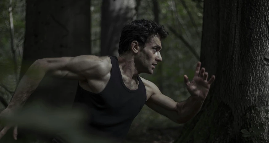 a man running in the woods through the forest