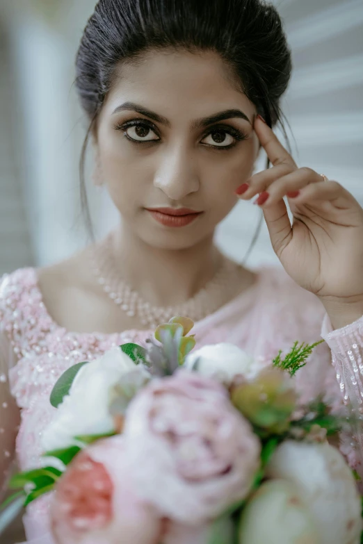 woman in pink dress holding a bouquet of flowers