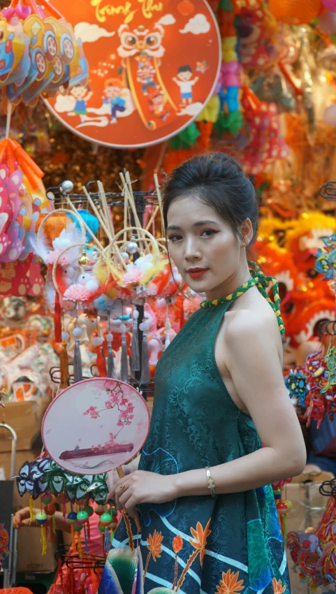 an oriental woman in green shirt holding small round doily