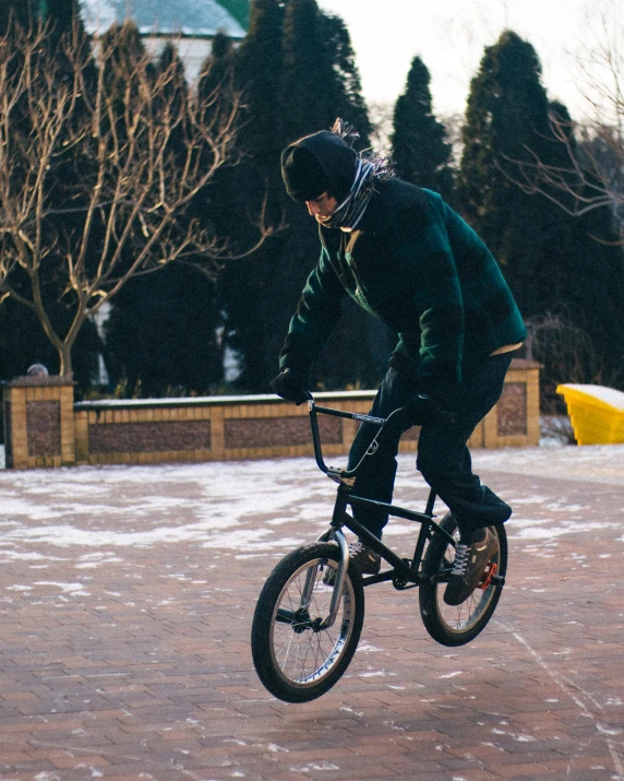 a man riding a black bike in the snow