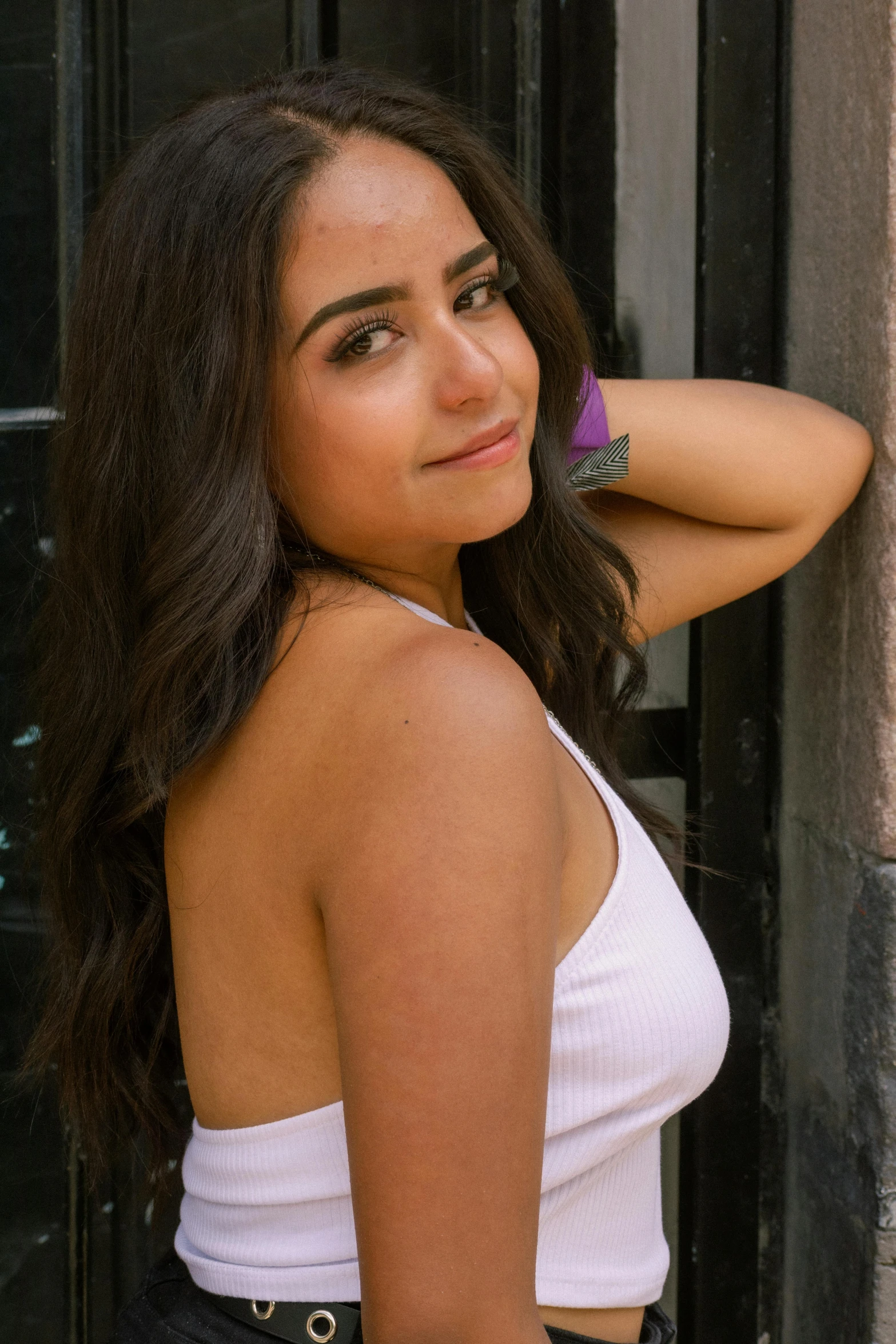 a woman is posing in front of a building