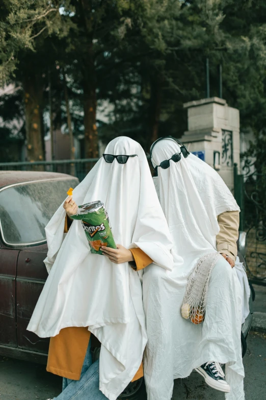 two people with covering clothes on walking down a street