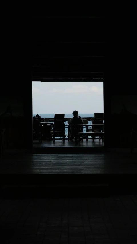 a dark room with a chair and some tables