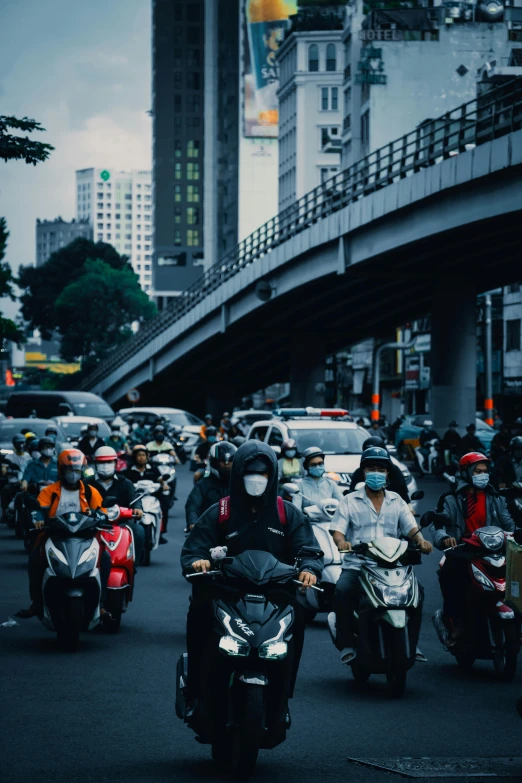 motorcycles drive down a city street with cars