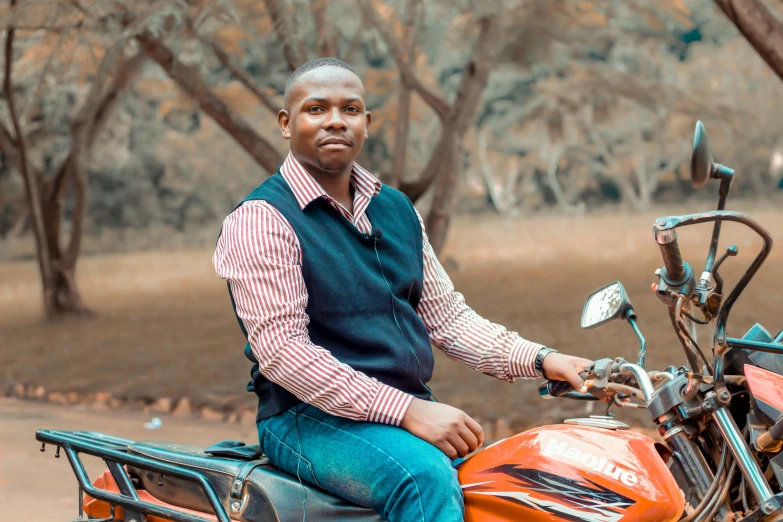 a man is sitting on a motorcycle with one hand on the seat