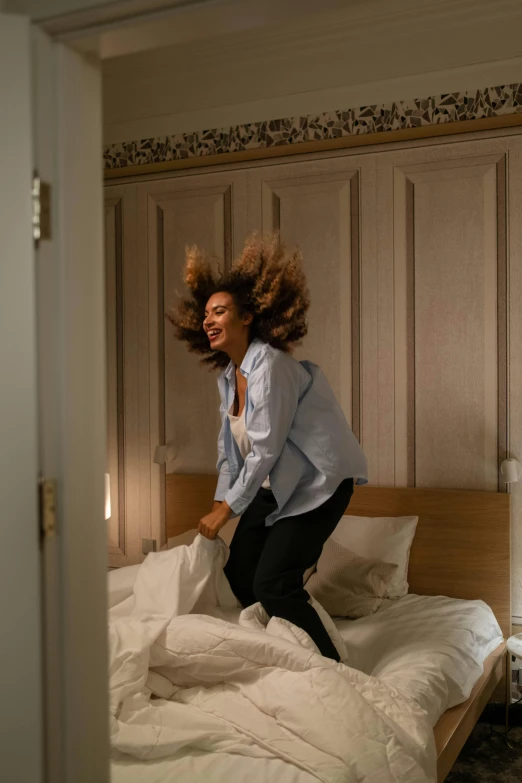 the woman is jumping on the bed in her room