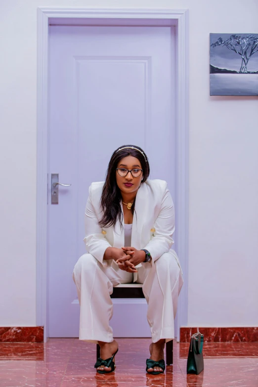 a woman is sitting in the middle of a chair in front of an open door