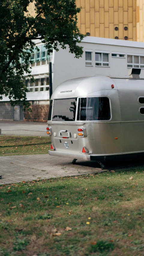 the back of an antique silver airstream parked on the street