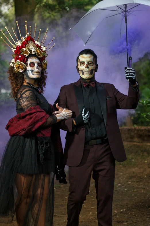 a man and woman wearing skeleton makeup walking outside in the rain