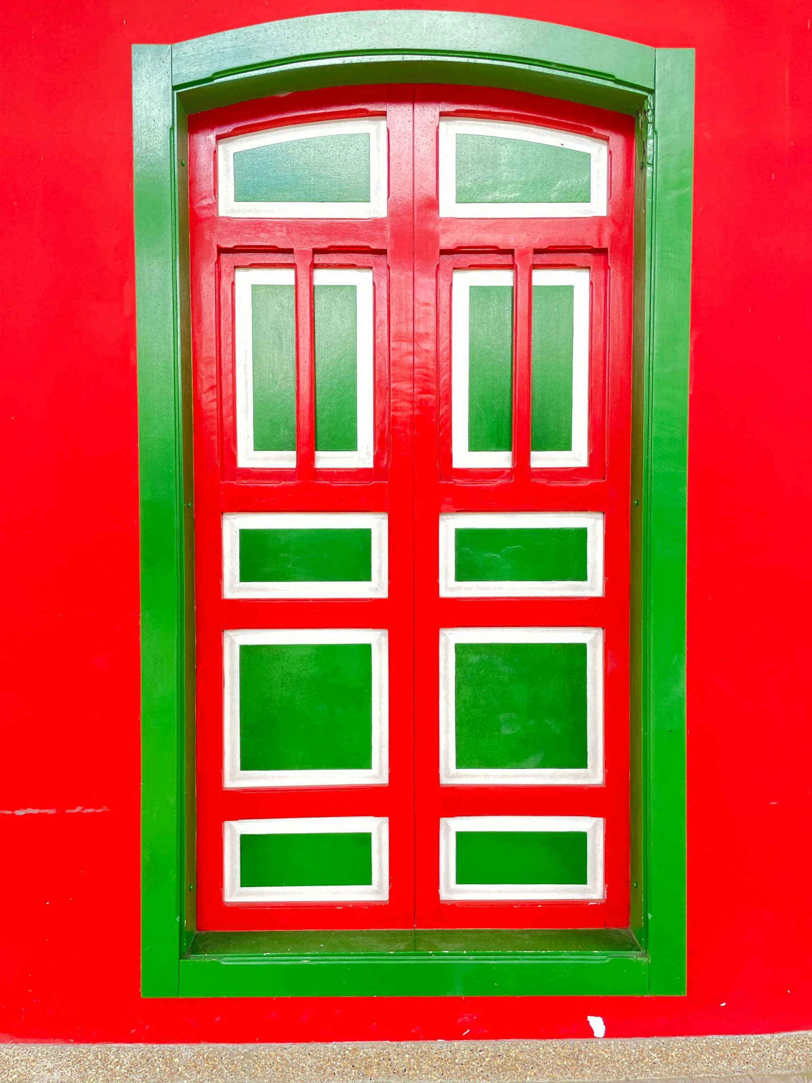 a red door with windows is shown on a red wall