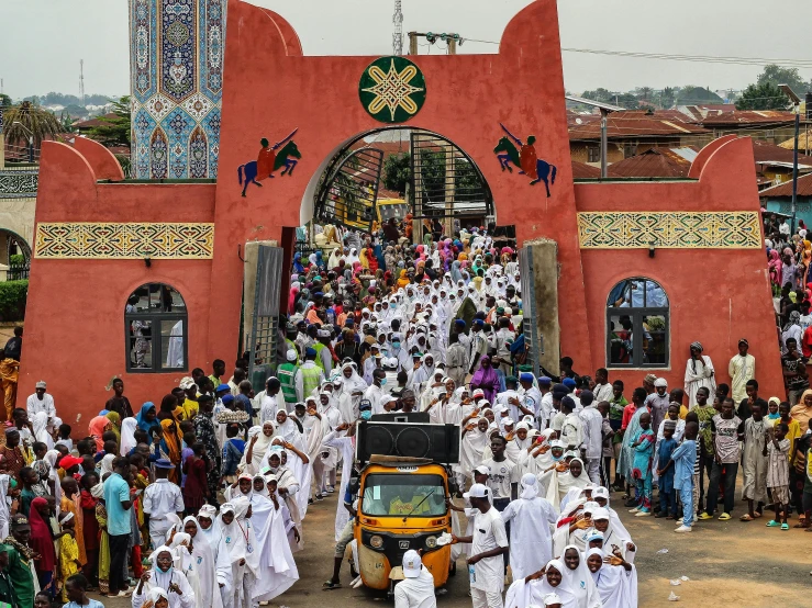 a large group of people standing near the entrance of a building