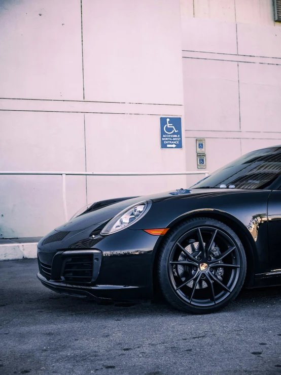 a black porsche parked in front of a building