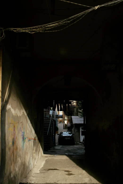 a light is shines into a dark tunnel in an alley