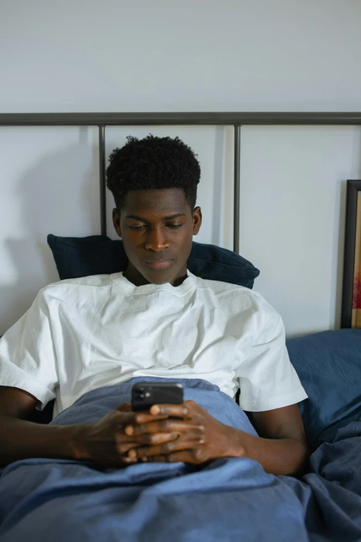 a man laying in bed using a cell phone