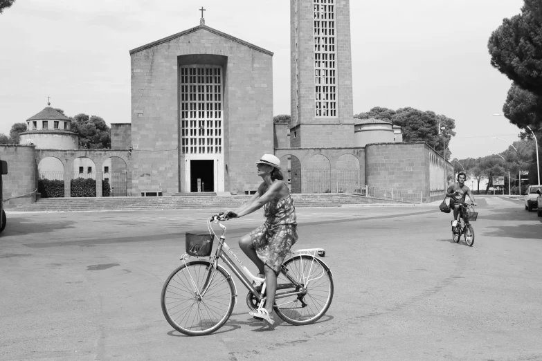 a woman riding a bike with a cathedral in the back