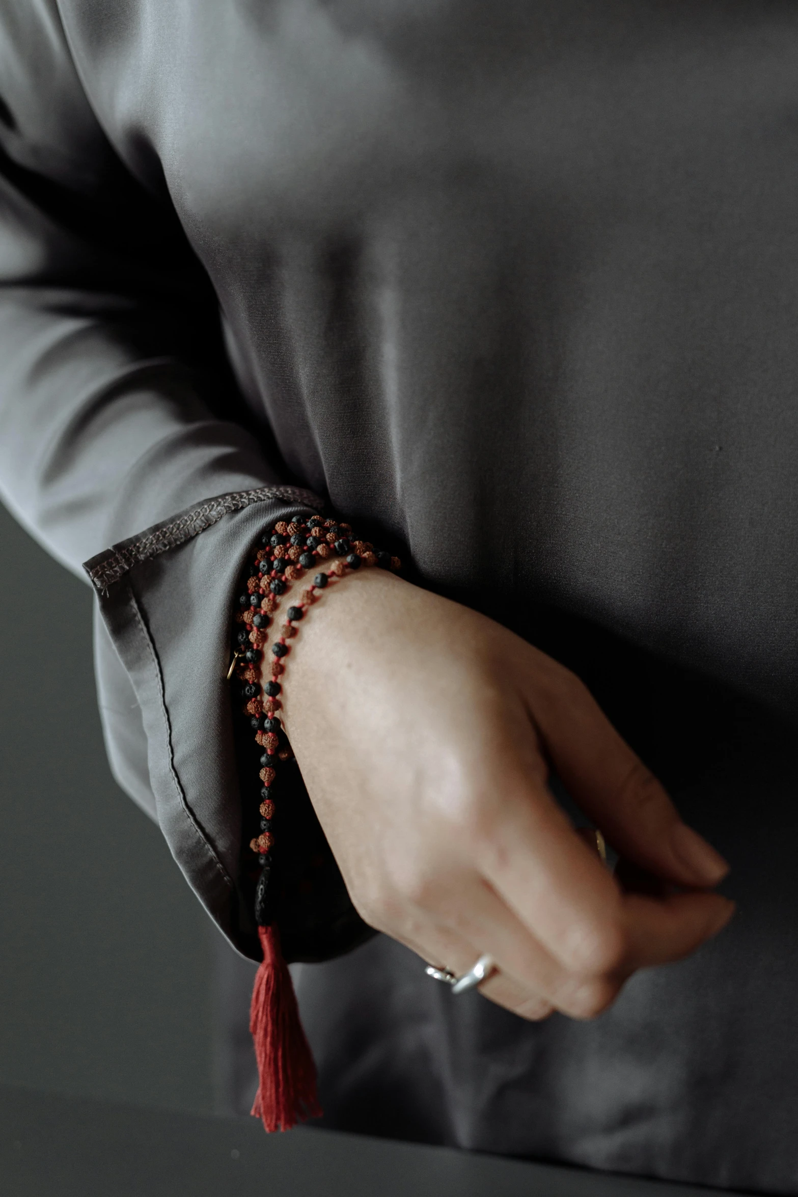 a woman wearing red beaded celets and a grey shirt