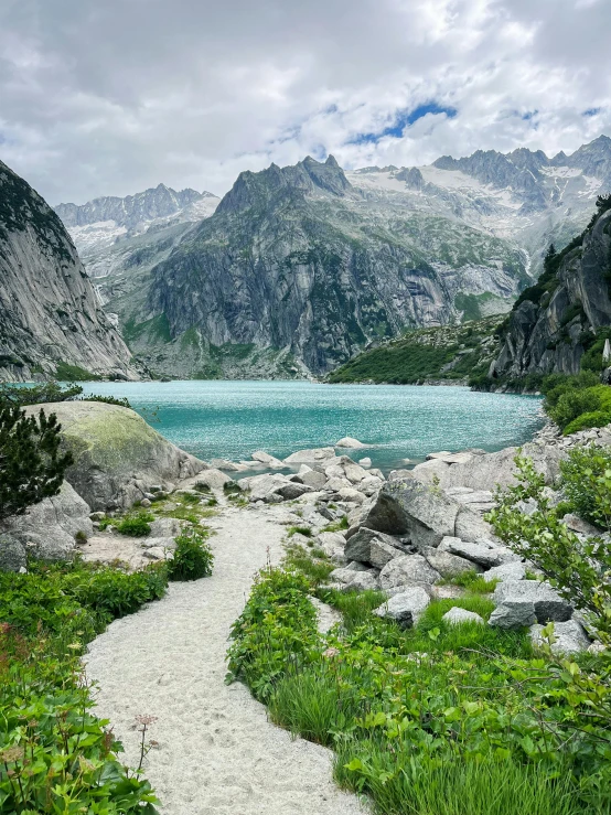 a path that is near a mountain with some water