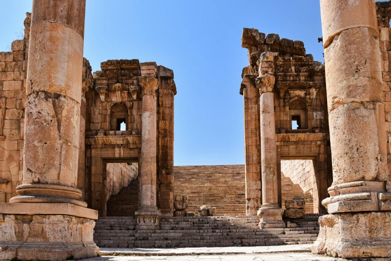 ruins, pillars and arches stand out in the bright blue sky