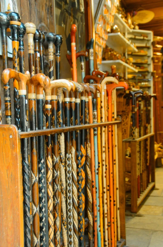 various types of baseball bats lined up by the rack